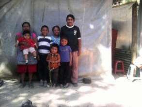 Cristobal and his family next to their old home.