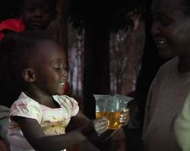 Child drinking ORS from Kit Yamoyo measuring cup