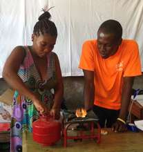 Magalie practices using an improved kerosene stove