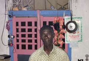 Jean-Jean charges a phone in his brightly lit home