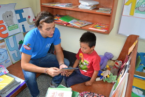 A volunteer helping one of our children read