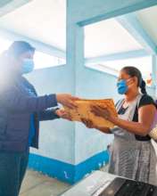 Mayra, handing-in her childrens' worksheets