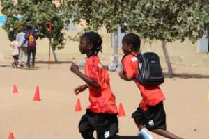 In soccer jerseys and with a school backpack