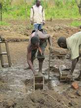 Men putting mud into brick molds