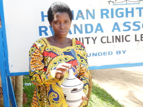 A beneficiary proudly displaying a basket she made