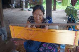 An artisan ties threads for a traditional motif.