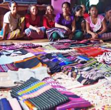 Artisans show handwoven fabrics they made to sell.