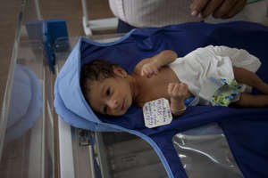 Tiny infant about to be wrapped up in the warmer