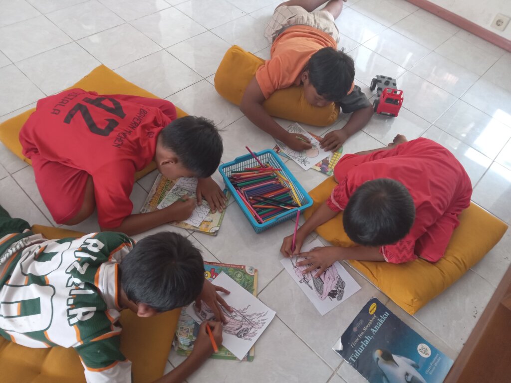 The boys are focused on coloring their vehicles