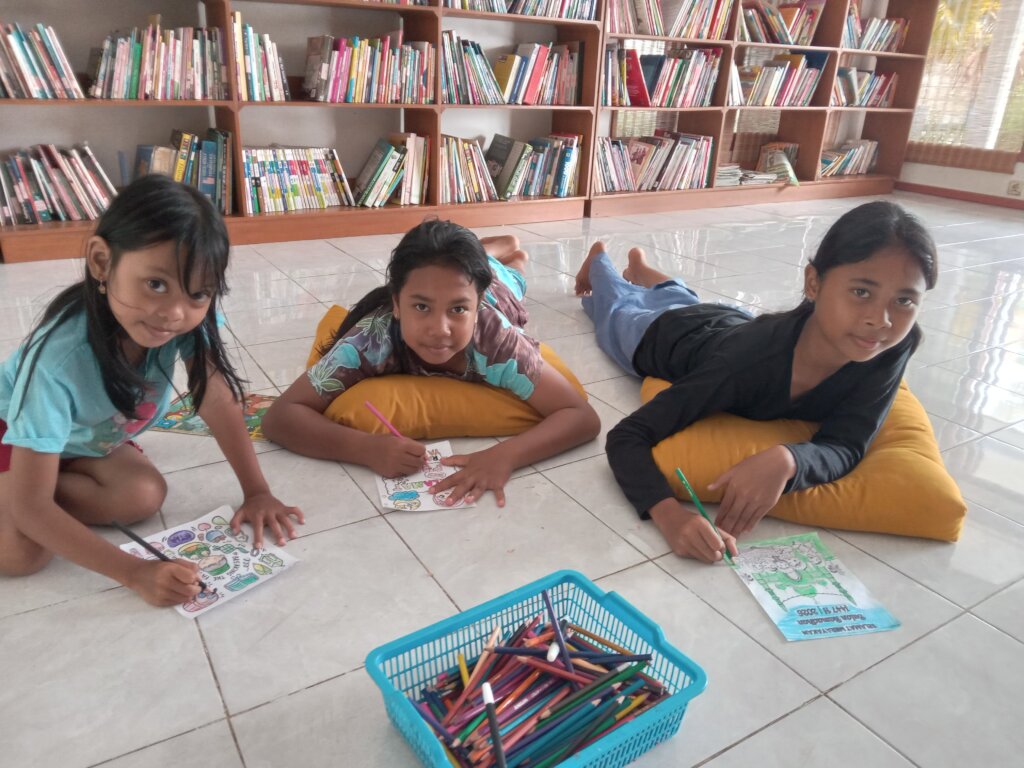 The girls happily share a box of colored pencils