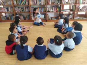 Ms. Rusti reading a book for the students