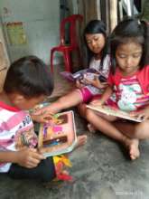 Reading together at home with their siblings