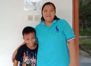 Fikri and his mother in front of  YUM's Library