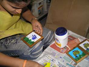 A beneficiary making a mosaic coaster