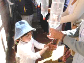 Young girl practicing hand washing at a work shop