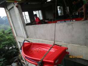 A boat being lowered from the workshop