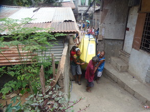Residents carry the boat through narrow alleyways