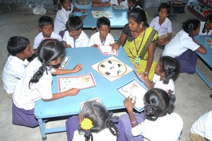 Para teacher helping children to read