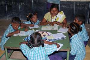 Para teacher helping children to read