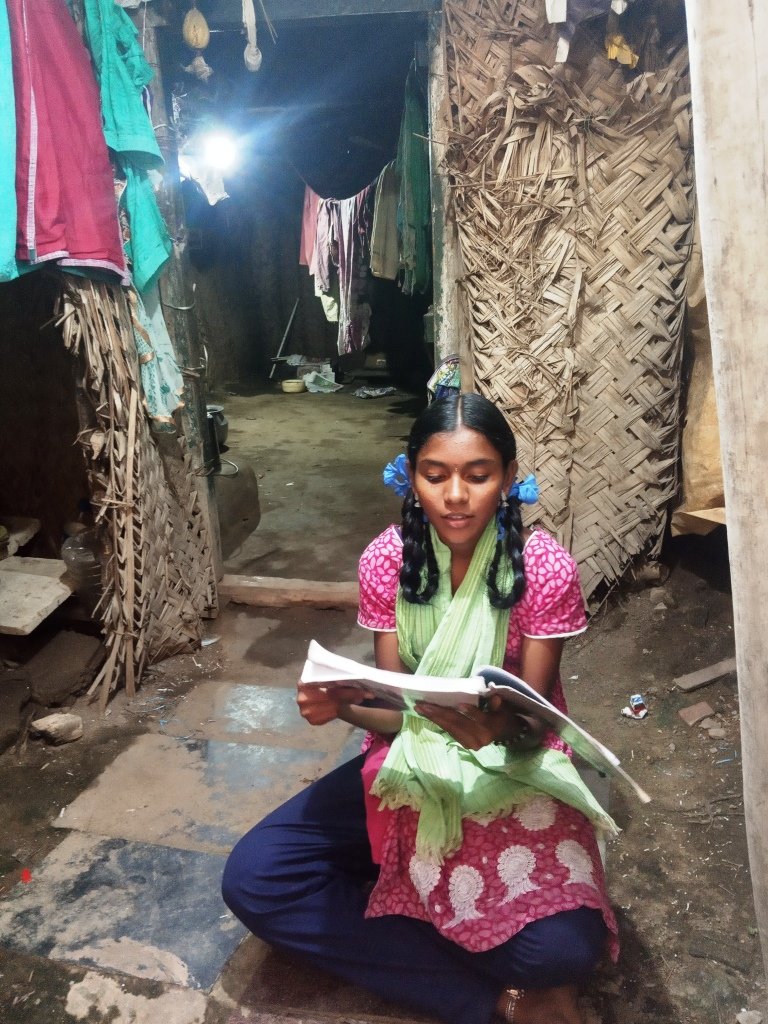 Piya studying in front of her home