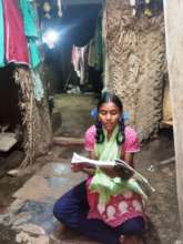 Piya studying in front of her home