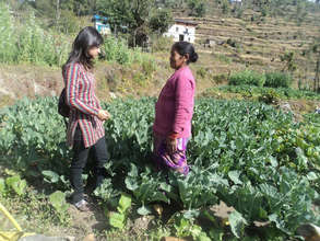 ETC staff member visiting a farmer in her garden