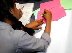 Student making placards for the plants.