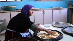 Um Hassan preparing food in the school cafeteria