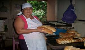 Heliodora Cardoza, a beneficiary, baking bread
