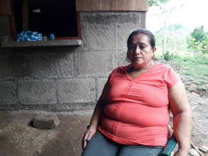 Justa outside her home