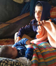 Aysar, at home with his new sister, in Susiya