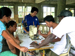 Community members learning to sew