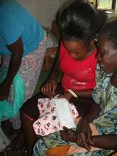 a woman being trained to make re-usable pads