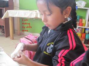 Deeply focused on making the parts of her Doll