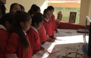 CW girls watch screen while students sing to them