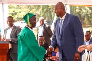 Jean-Claude congratulates a graduate.