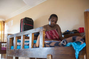 A Sega student relaxes in her bunk bed