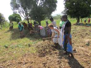 Carol & Jinja beaders hand hoeing new land Feb2014