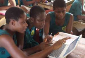 Children at Mawuli Basic School share a laptop