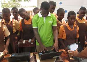 Pupils watch technicians configure the new laptops