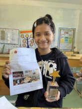 Loi with the trophy and contest winner letter!