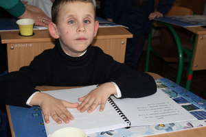 A blind boy enjoying the tales in Braille
