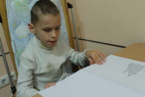 A blind boy reading Braille book