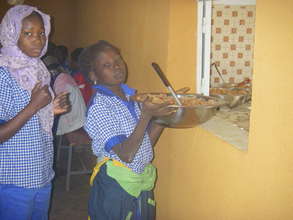 A student takes a serving bowl from the kitchen