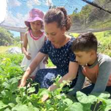 Dona Jenny and her children in their lush garden