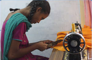 Adolescent girl stitching with the sewing machine