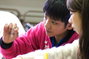 A boy is working together with a volunteer student