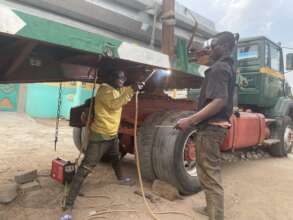 Welder at work fixing a stranded heavy truck