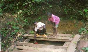 Children collect water from a pond improvised with