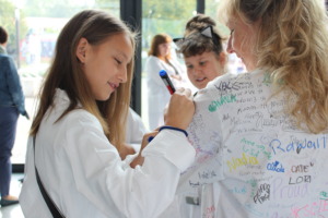 greenlight girl in Krakow signs Founder's labcoat